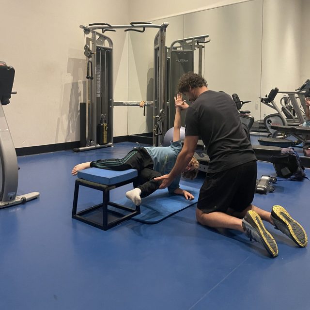 La Jolla Personal Trainer helping young client to stabilize his body in a core strength drill