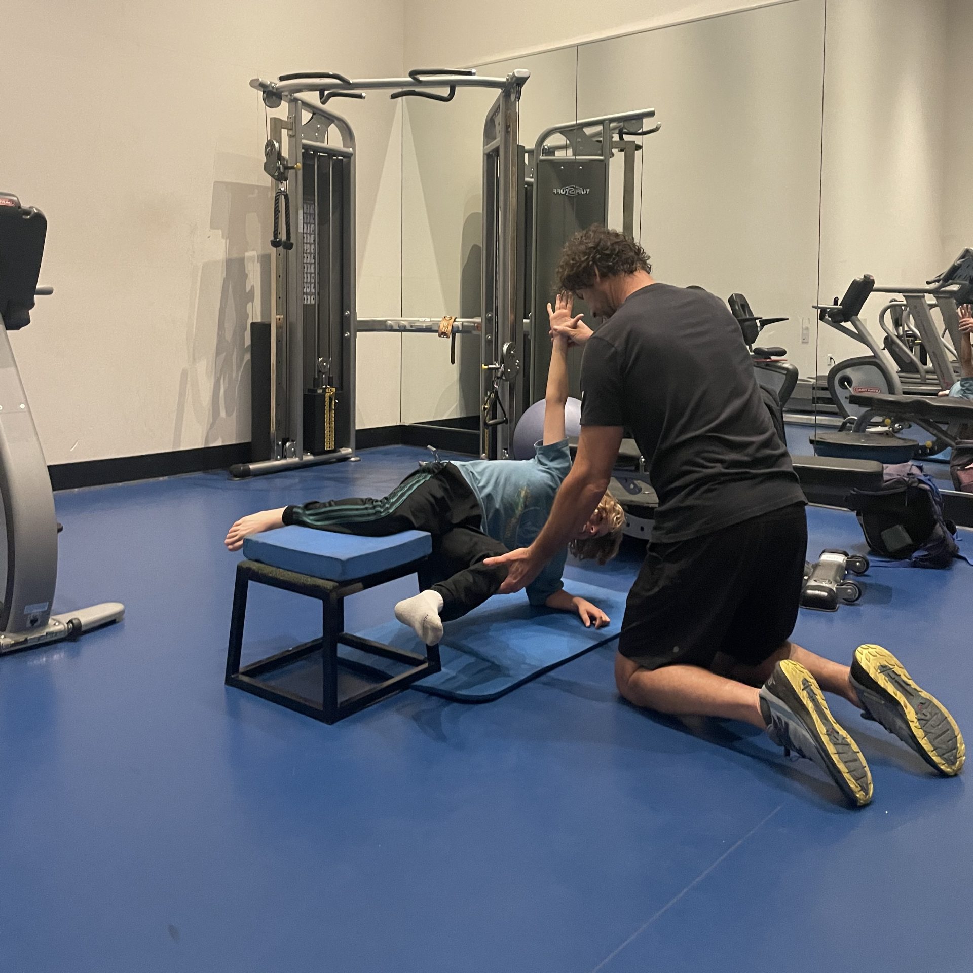 La Jolla Personal Trainer helping young client to stabilize his body in a core strength drill