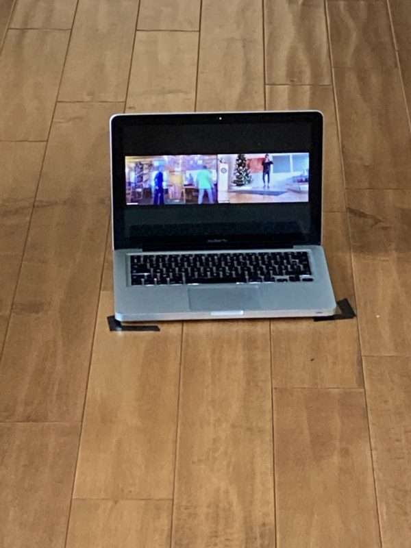 computer on the floor where a personal trainer is teaching zoom class