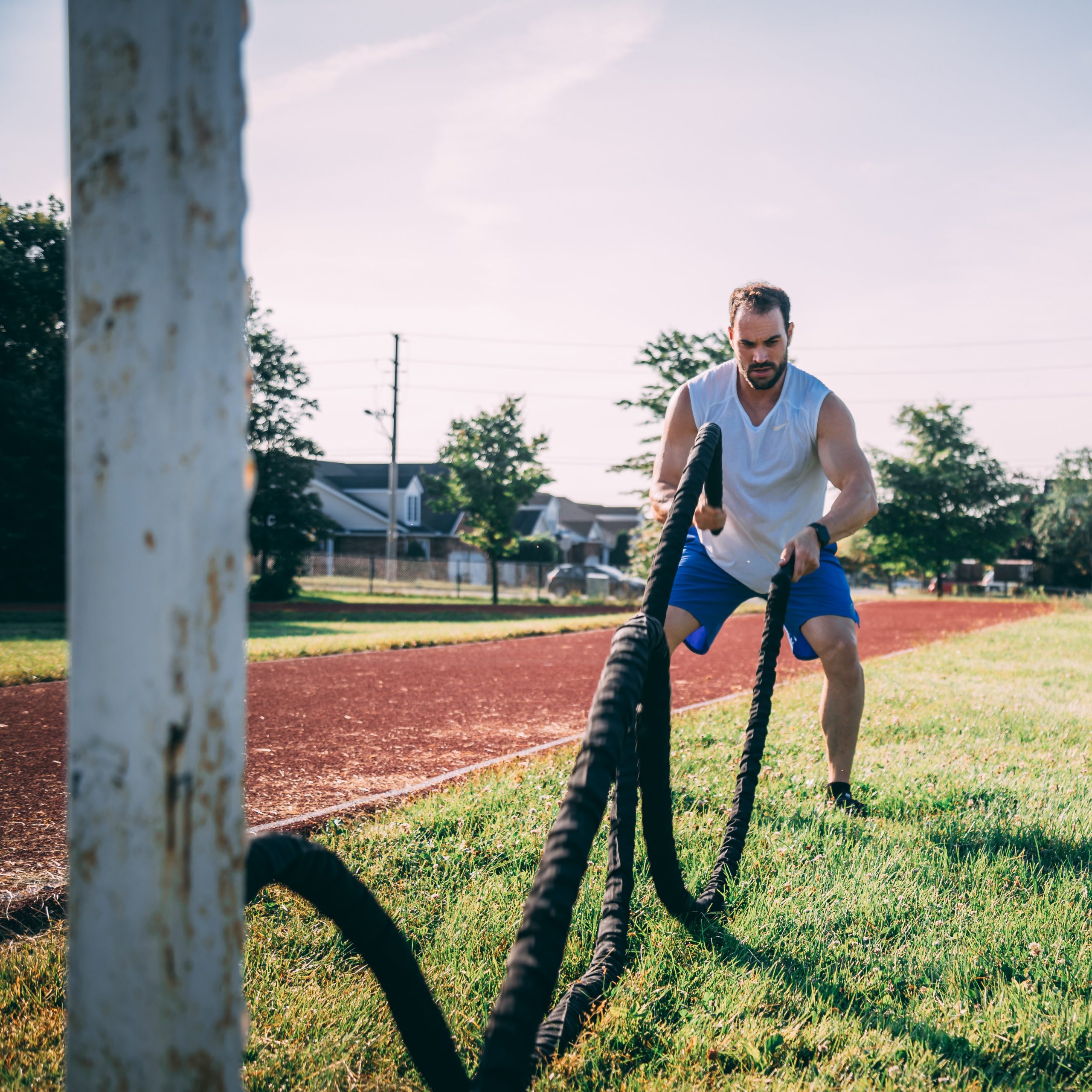 Man in his twenties swinging a combat rope to lose weight to follow HIIT protocol set up by Fabien Uteau