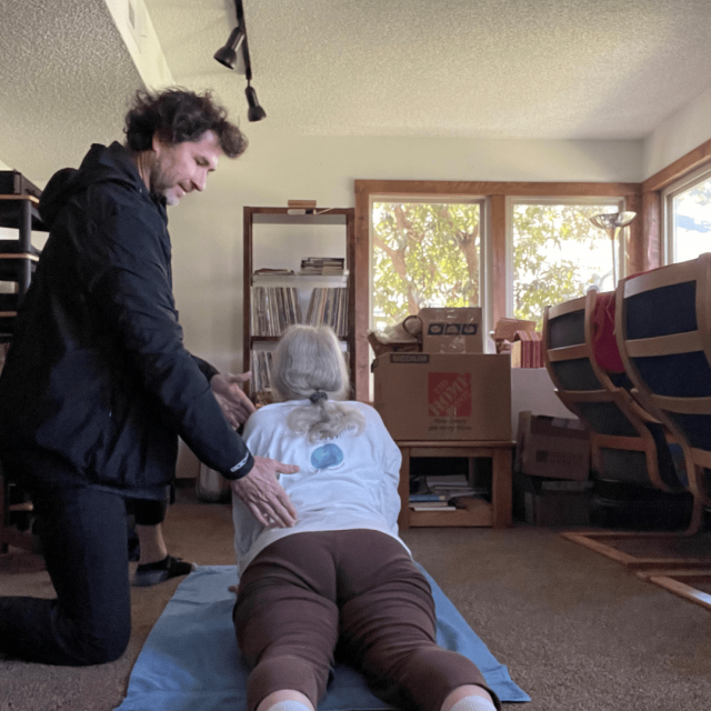 San Diego Personal Trainer is helping an old lady to perform a yoga pose
