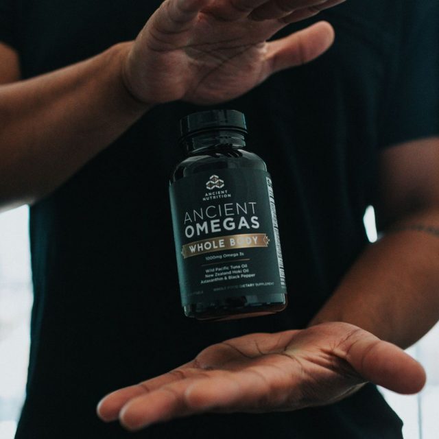Black male holding a bottle of omegas in between his hands