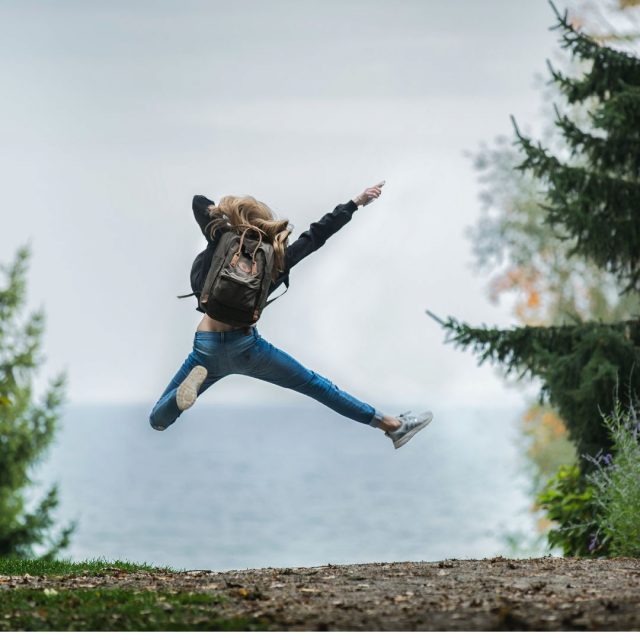 Woman jumping with a backpack